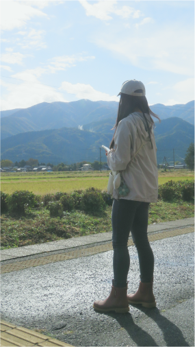 Portrait of the back of Wing Pang on a train platform in Niigata, Japan, looking at the mountain scenary.