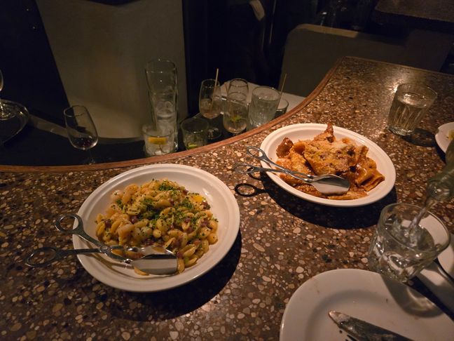 Two plates of pasta, one is a lamb ragu and the other is prawn with bacon.